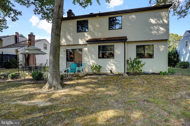 rear view of property with a yard and a patio area