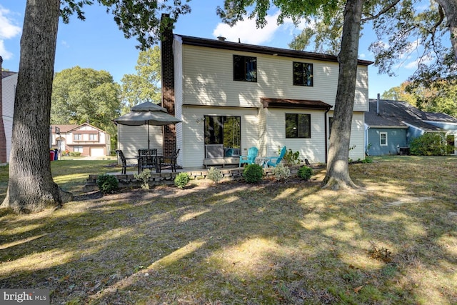 back of house featuring a wooden deck and a lawn