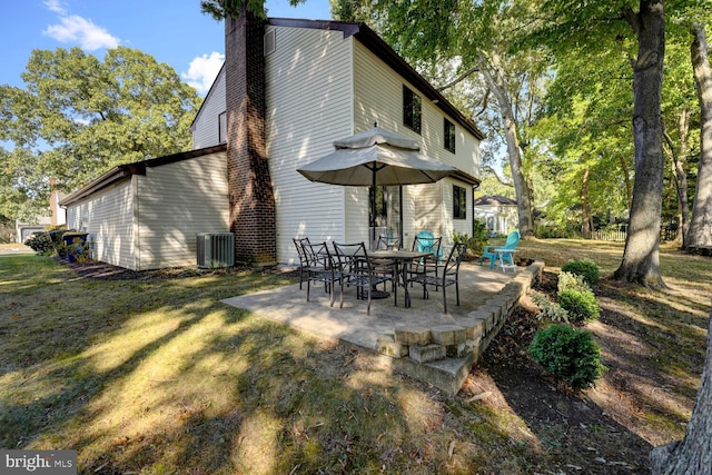 rear view of property featuring a patio, a yard, and cooling unit