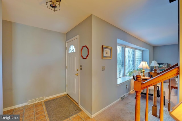 carpeted foyer featuring a healthy amount of sunlight