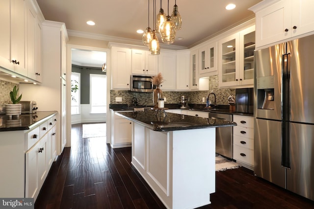 kitchen featuring stainless steel appliances, a kitchen island, white cabinetry, and crown molding