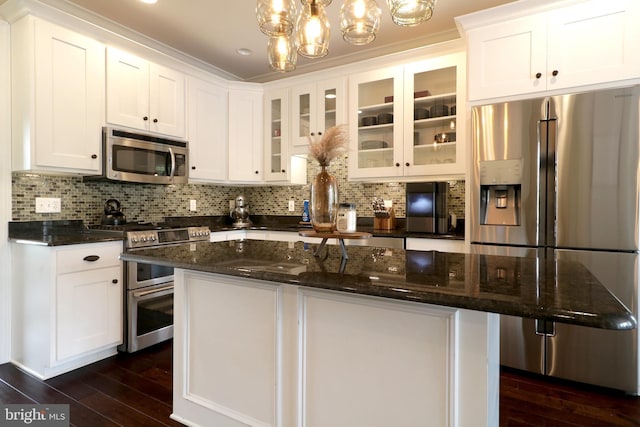 kitchen featuring decorative backsplash, pendant lighting, stainless steel appliances, and white cabinetry