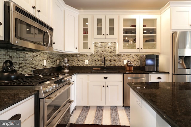 kitchen with white cabinets, decorative backsplash, sink, and stainless steel appliances