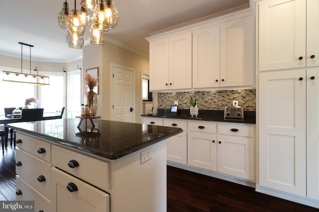 kitchen with decorative backsplash, white cabinetry, dark wood-type flooring, and decorative light fixtures