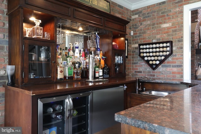 bar featuring ornamental molding, sink, and brick wall