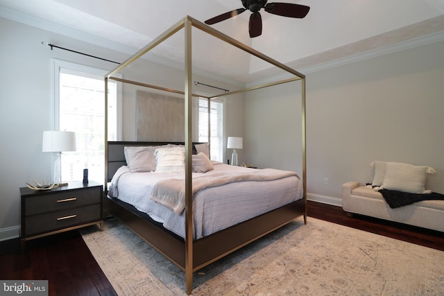 bedroom featuring dark hardwood / wood-style flooring, ceiling fan, and crown molding