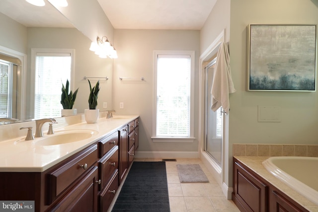 bathroom with a wealth of natural light, tile patterned flooring, vanity, and plus walk in shower