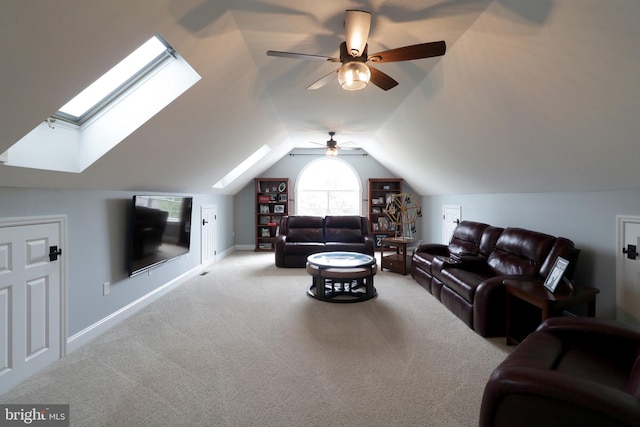 carpeted living room featuring ceiling fan and vaulted ceiling with skylight