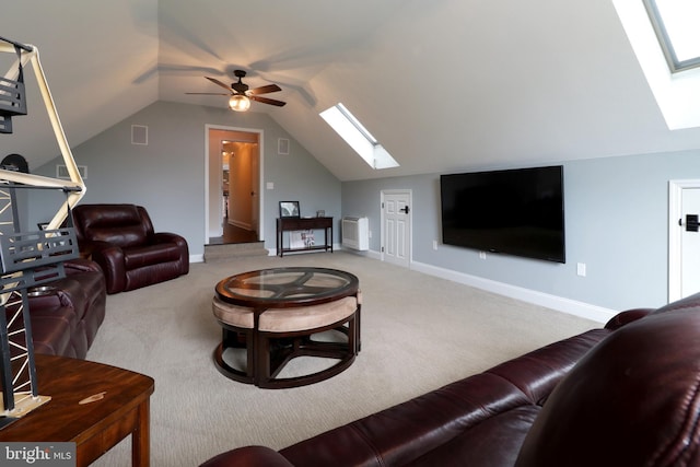 carpeted living room featuring ceiling fan and lofted ceiling with skylight