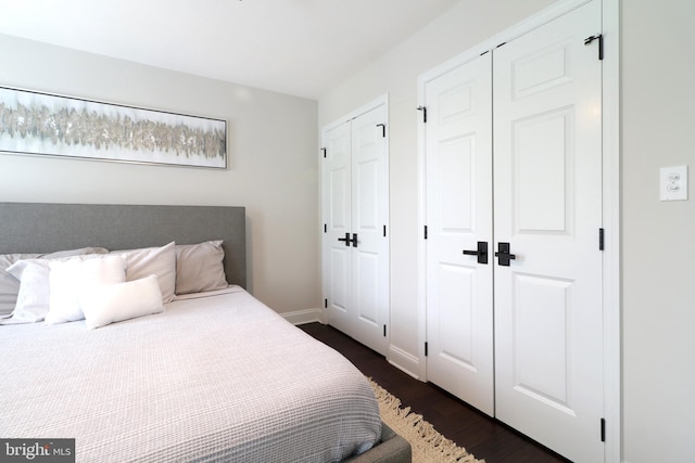 bedroom featuring dark hardwood / wood-style flooring and multiple closets