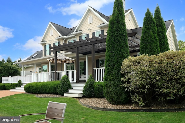 view of front facade with covered porch, a pergola, and a front lawn