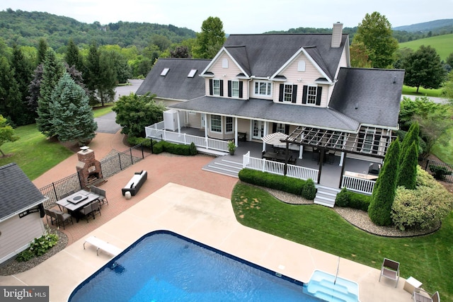 rear view of property featuring a lawn, an outdoor hangout area, and a patio