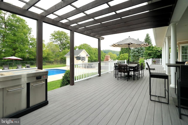 wooden terrace featuring an outbuilding and a pergola