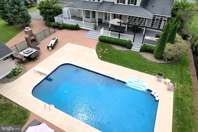 view of pool with a diving board, a patio area, and a yard