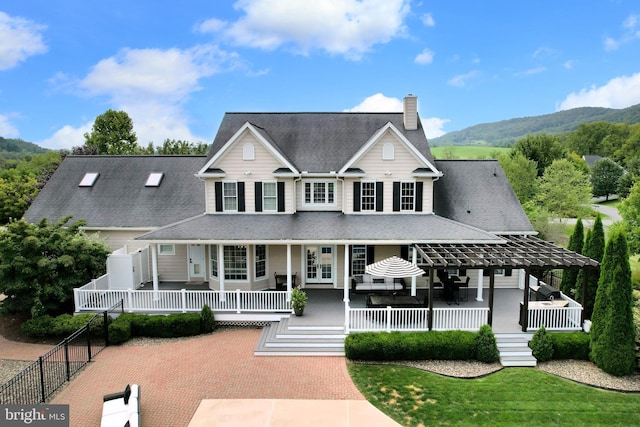 view of front of property with a mountain view, a front lawn, and a porch