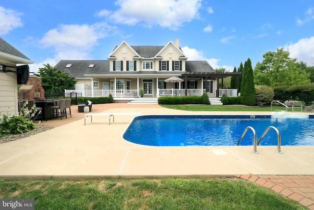 view of swimming pool featuring a pergola, an outdoor bar, and a patio