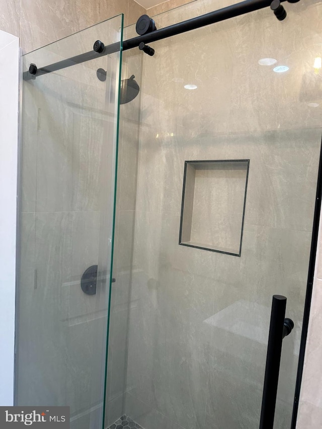 bathroom featuring a shower with door