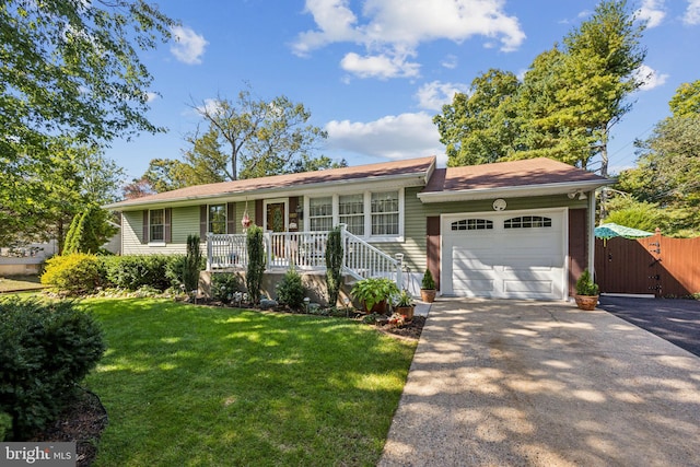 ranch-style home featuring a garage, a front yard, and covered porch