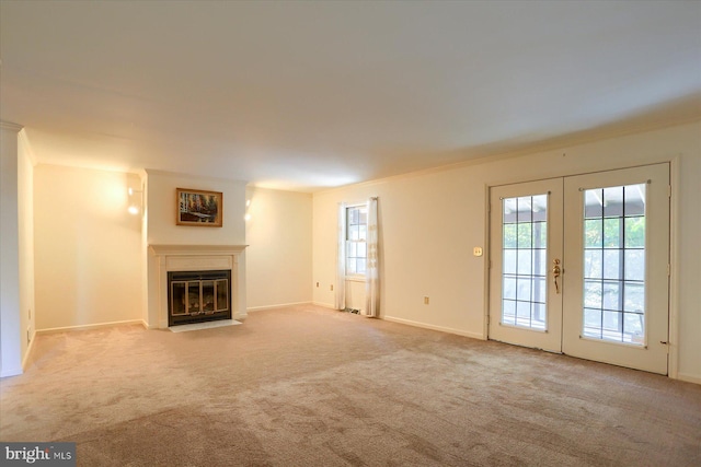 unfurnished living room featuring french doors, light carpet, and ornamental molding