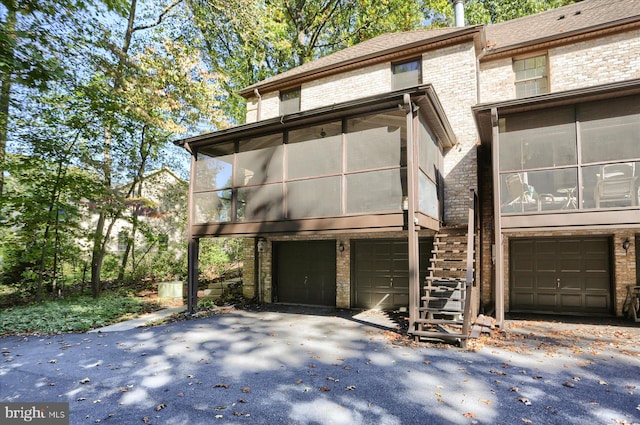 view of front of home with a garage and a sunroom