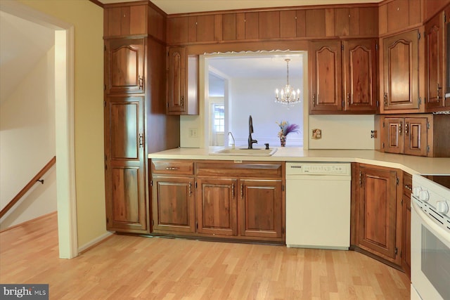 kitchen featuring hanging light fixtures, a chandelier, light wood-type flooring, sink, and white appliances