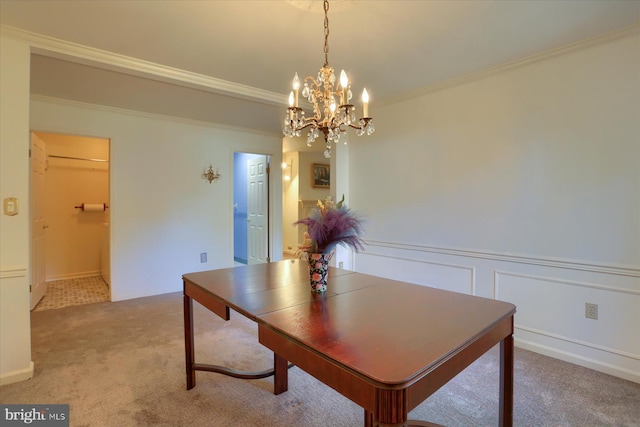 carpeted dining room with ornamental molding and a chandelier