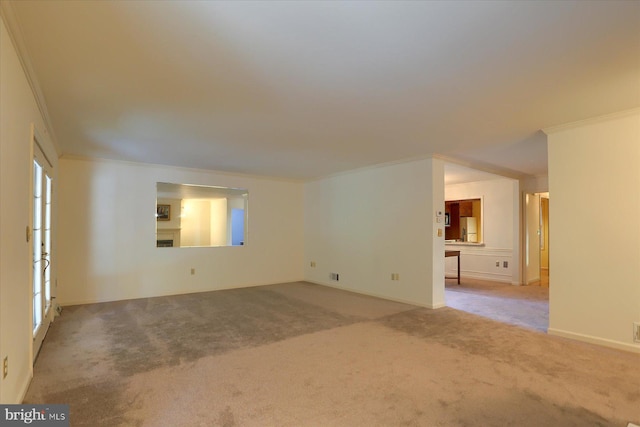 carpeted empty room with a wealth of natural light and crown molding