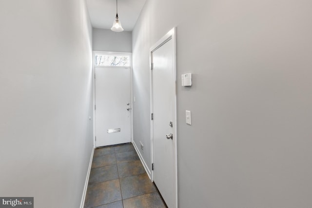 hallway featuring dark tile patterned floors