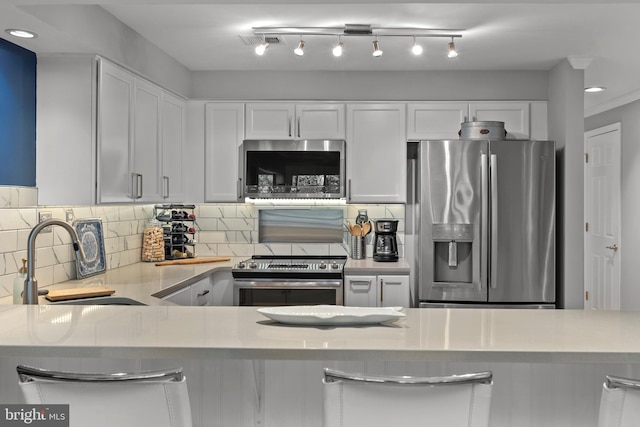 kitchen with stainless steel appliances, white cabinetry, and sink