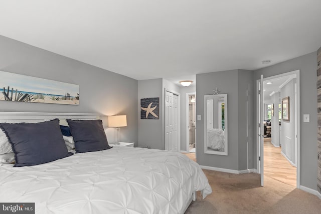 carpeted bedroom featuring a closet and connected bathroom