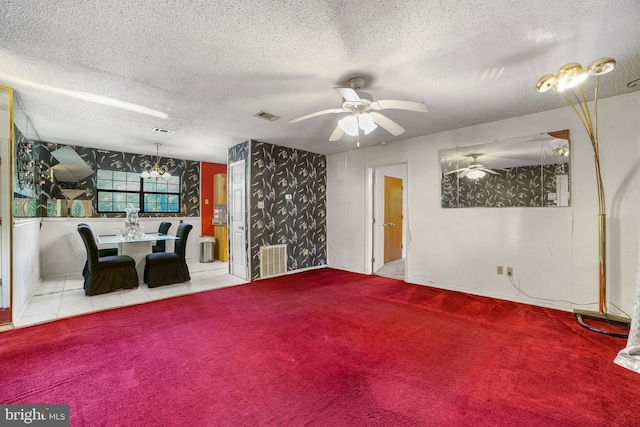 unfurnished living room with carpet, a textured ceiling, and ceiling fan