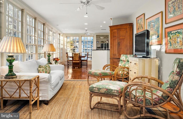 living area featuring ceiling fan, sink, and light hardwood / wood-style flooring