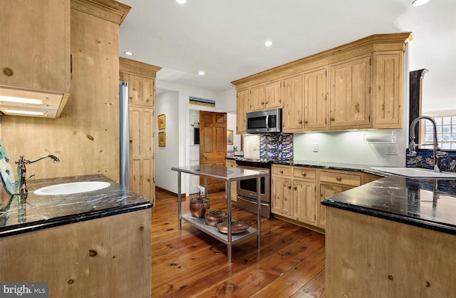 kitchen with light brown cabinetry, sink, appliances with stainless steel finishes, and dark wood-type flooring