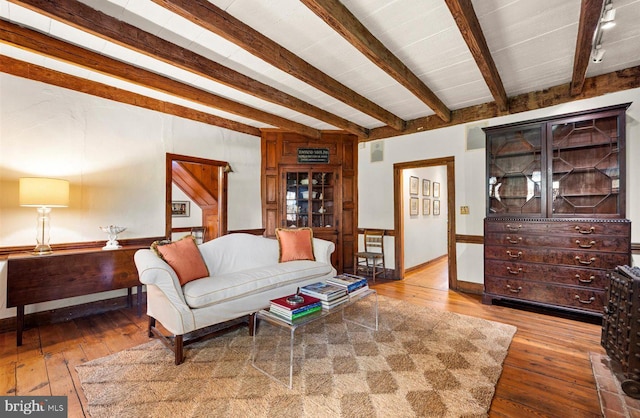 living room featuring wood-type flooring and beam ceiling