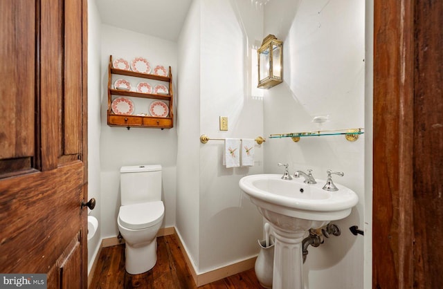 bathroom featuring toilet and wood-type flooring