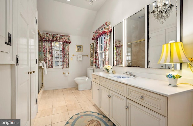 bathroom with vanity, vaulted ceiling, tile patterned flooring, toilet, and walk in shower