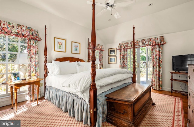 bedroom featuring light wood-type flooring, vaulted ceiling, and ceiling fan