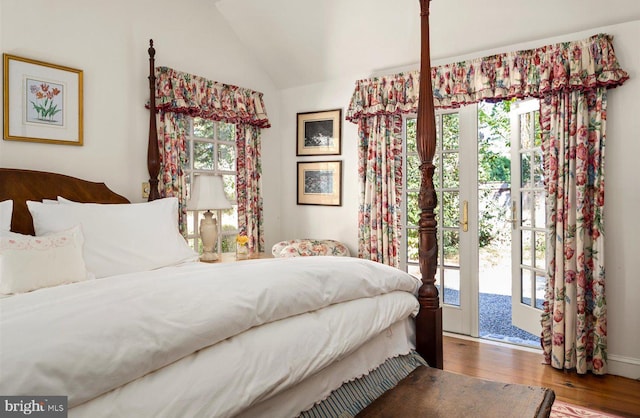 bedroom with access to outside, multiple windows, lofted ceiling, and hardwood / wood-style flooring