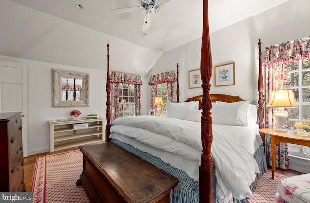 bedroom with hardwood / wood-style flooring, ceiling fan, lofted ceiling, and multiple windows