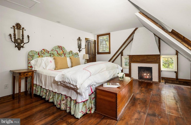 bedroom featuring a fireplace and dark hardwood / wood-style flooring