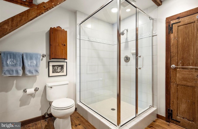 bathroom with hardwood / wood-style floors, a shower with door, and toilet