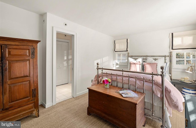 bedroom featuring light colored carpet and multiple windows