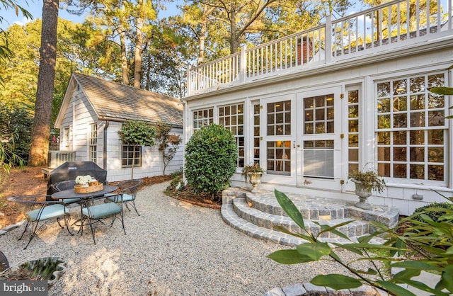 back of property featuring a balcony and a patio area