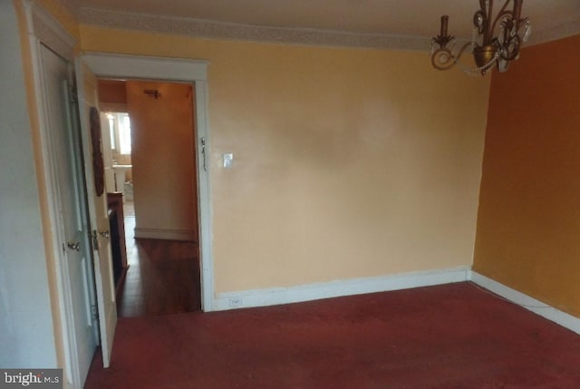 unfurnished room featuring a notable chandelier and carpet flooring