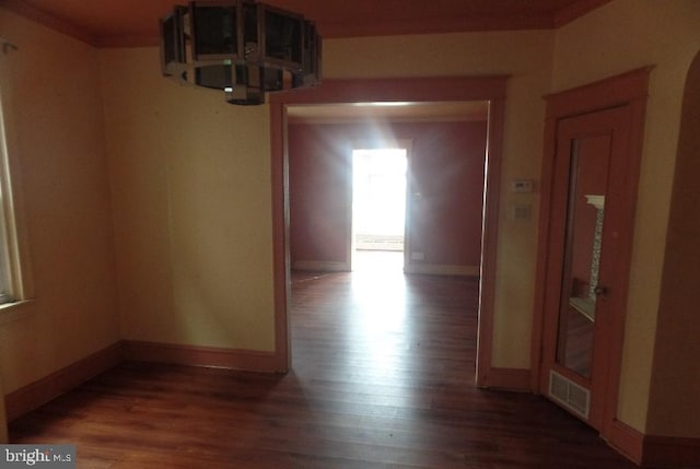 hall featuring ornamental molding and dark hardwood / wood-style flooring