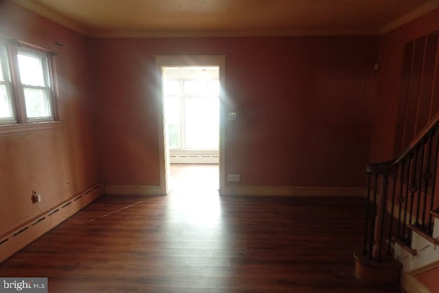 spare room featuring crown molding, dark hardwood / wood-style floors, and a baseboard heating unit