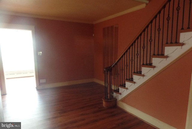 stairway featuring ornamental molding, hardwood / wood-style floors, and a baseboard heating unit