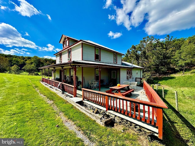 back of house with a wooden deck and a yard