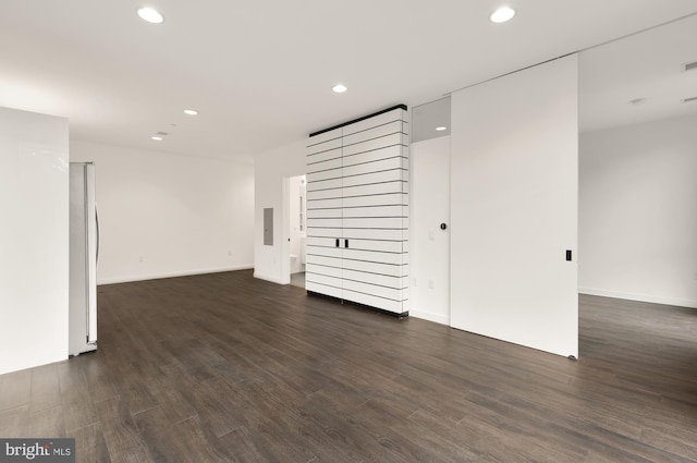 unfurnished room with dark wood-type flooring