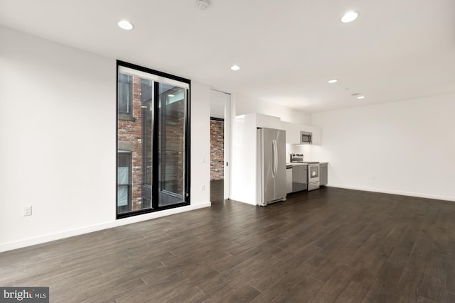 unfurnished living room with dark wood-type flooring